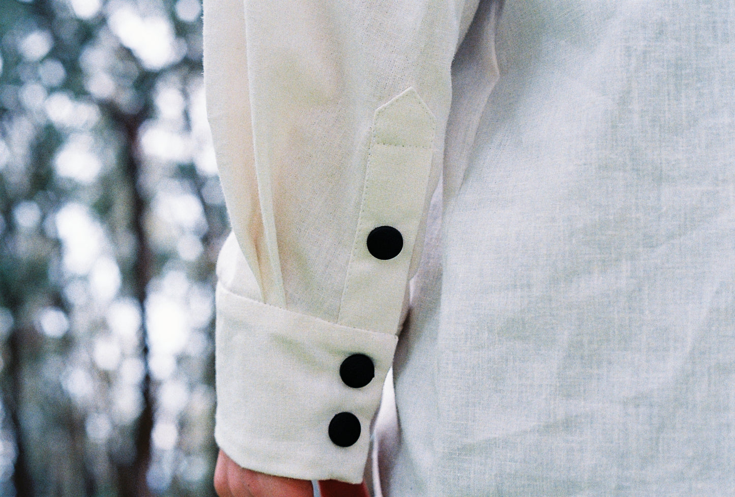 A closeup image of the sleeve and cuff of a white shirt