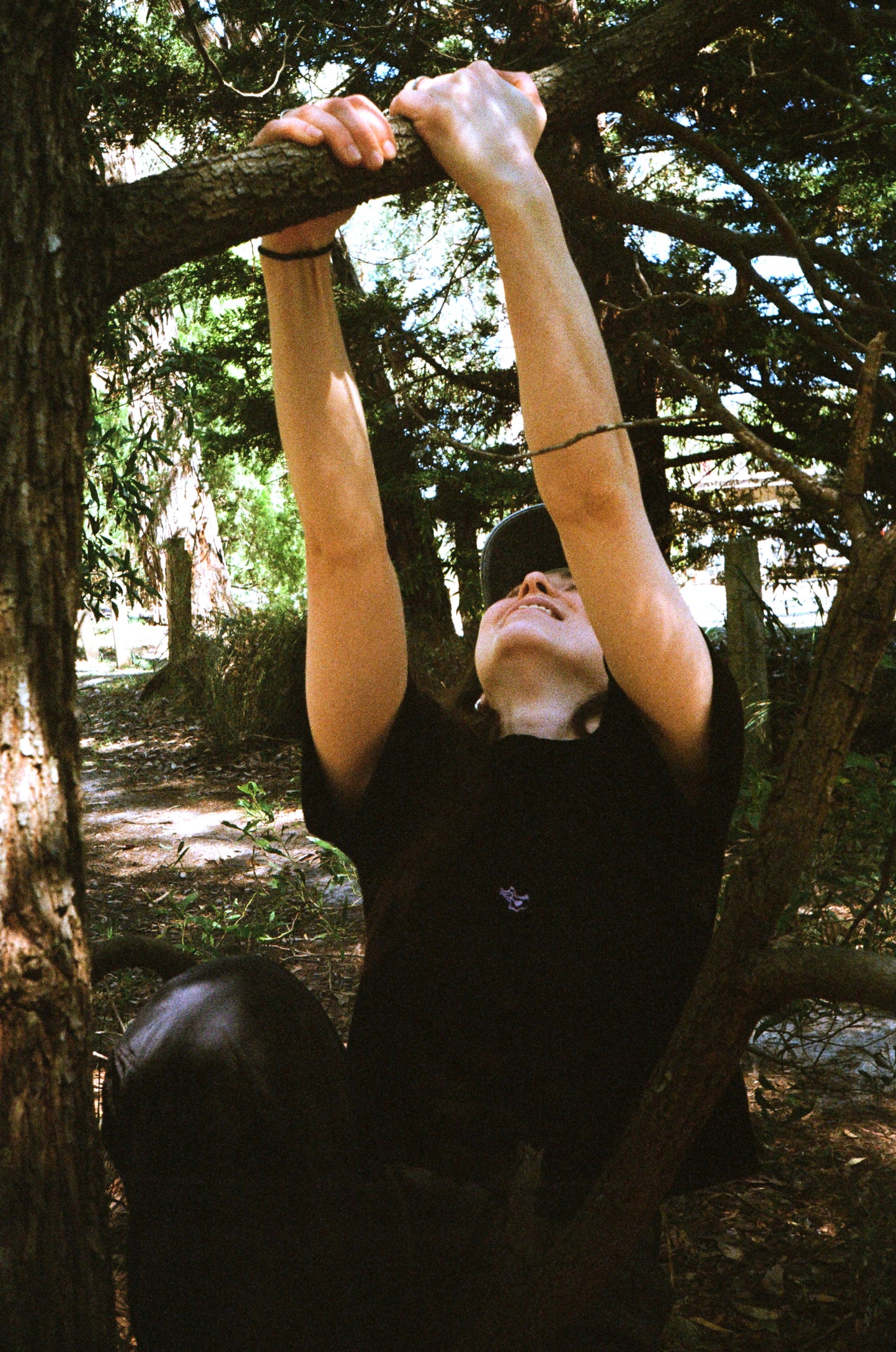 A woman swinging on a tree in a black shirt