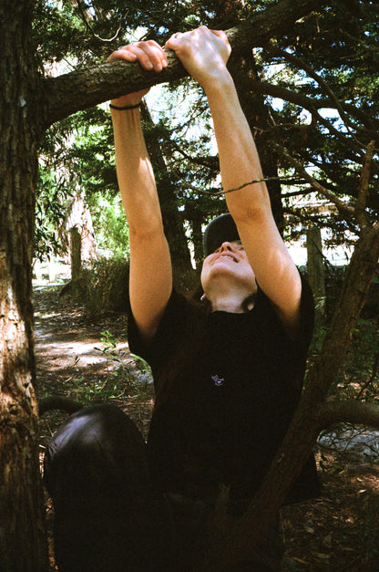 A woman swinging on a tree in a black shirt