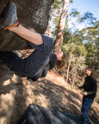 A man in action bouldering in the bush 