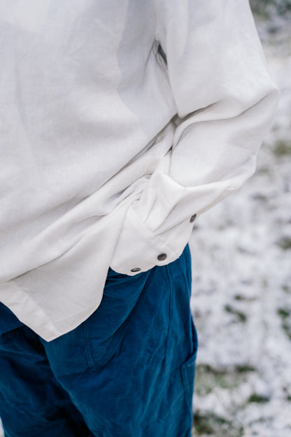 A detail image of the white shirt sleeve in the pant pocket.