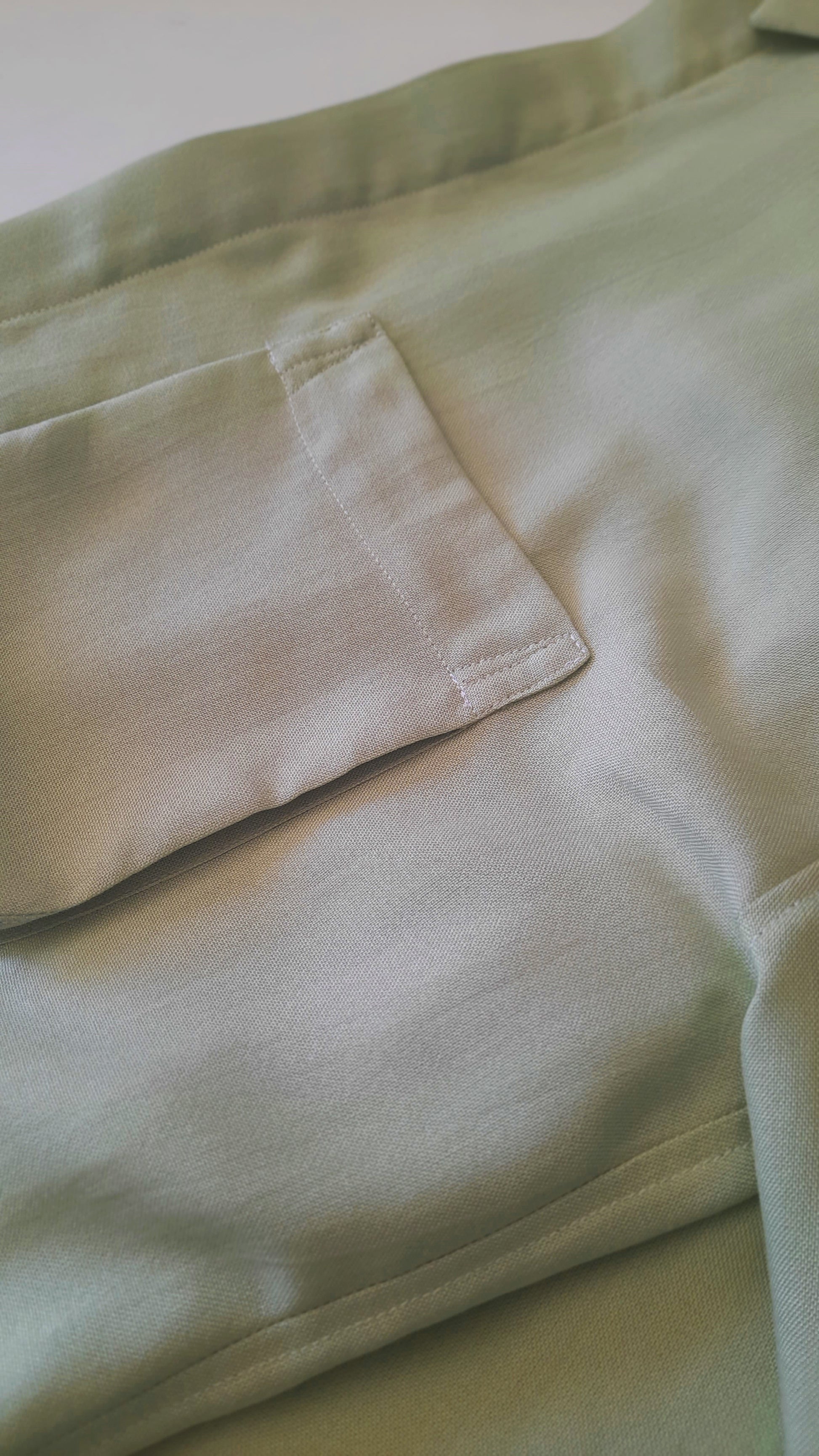 a detailed image of the pocket on a reen shirt