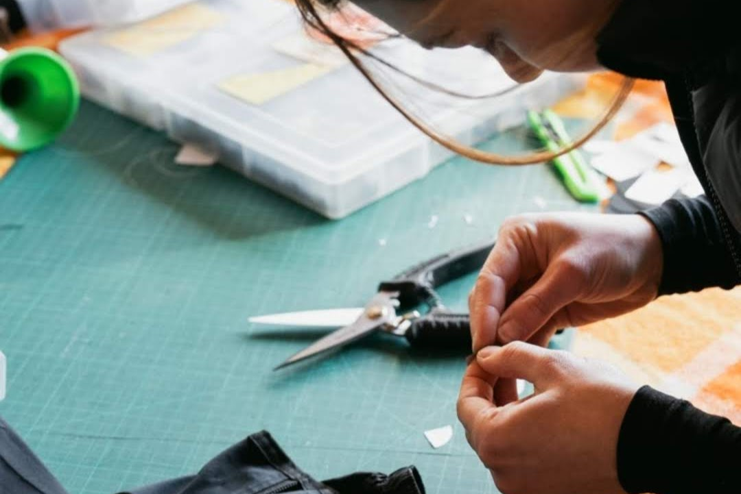 a lady repairing outdoor gear