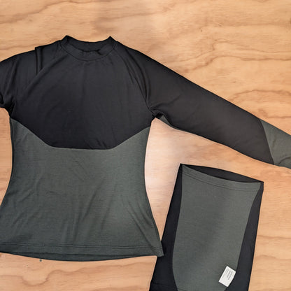 A shirt with a black top and olive bottom, pictured with a balaclava.