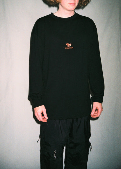 Front on photo of man wearing long sleeve merino tee standing in front of white background.