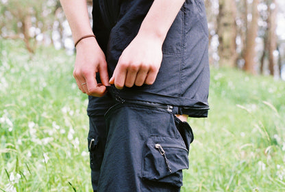 A close up of a black pant leg that has been half zipped off
