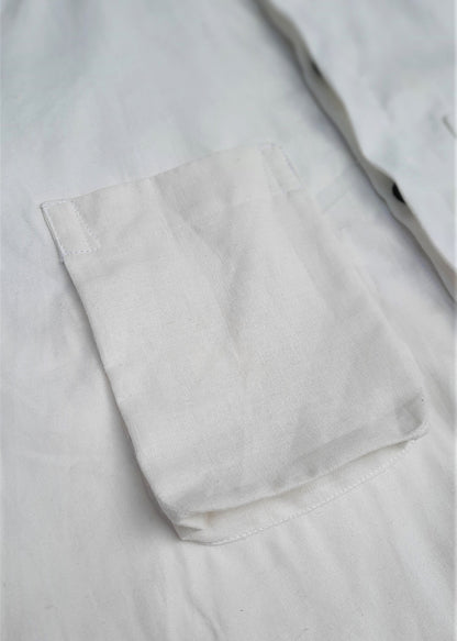 A closeup image of a white shirt with a pocket on the chest