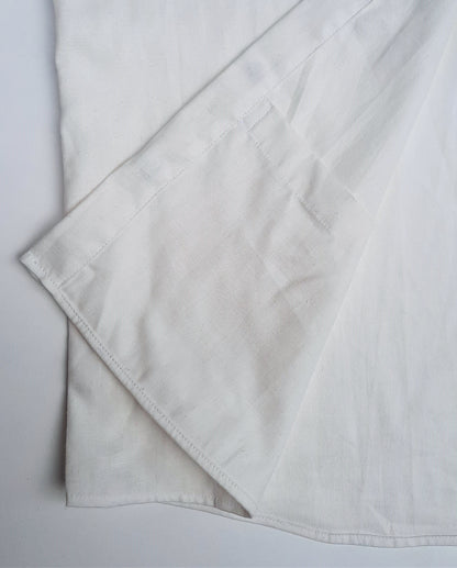 A detail image of the internal pocket at the base of a white shirt