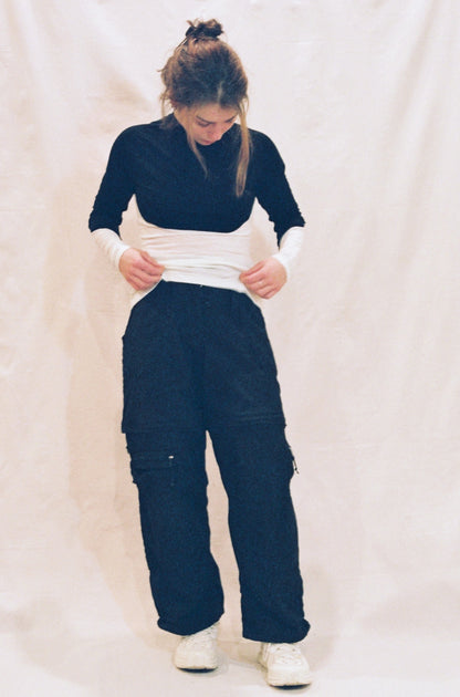 A front image of a girl wearing a long sleeve shirt that has a white bottom and black top